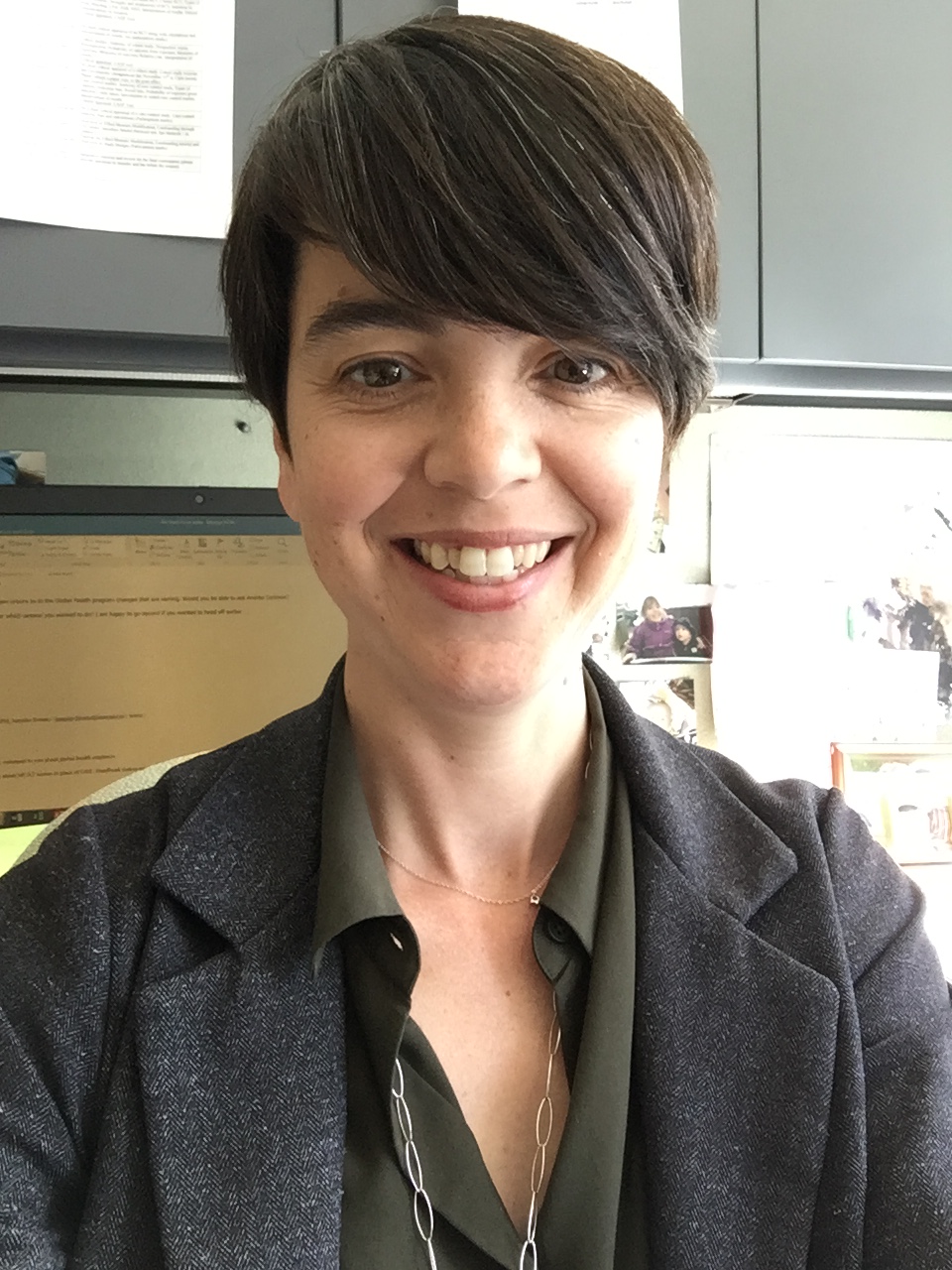 head and upper body shot of Jen Brooks wearing black shirt with open collar and smiling