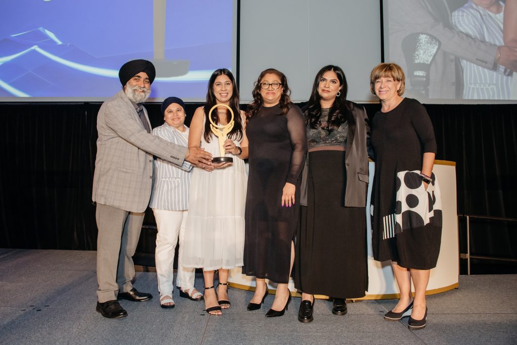 Image of Avis Favaro presenting the Excellence in Health Communications Award at the Ontario Health System Quality and Innovation Awards Ceremony to the Dementia Strategic Fund Team