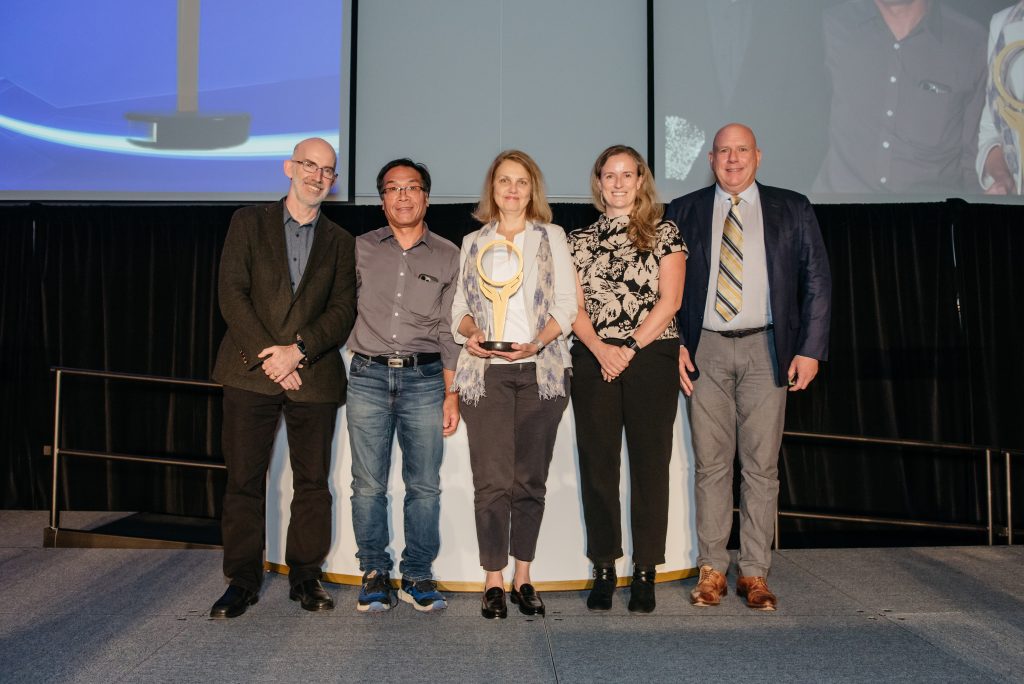 Image of Paul Dalla Lana presenting the Improved Value and Sustainability Award to the Toronto Regional Arthroplasty Collaborative (TRAC) team