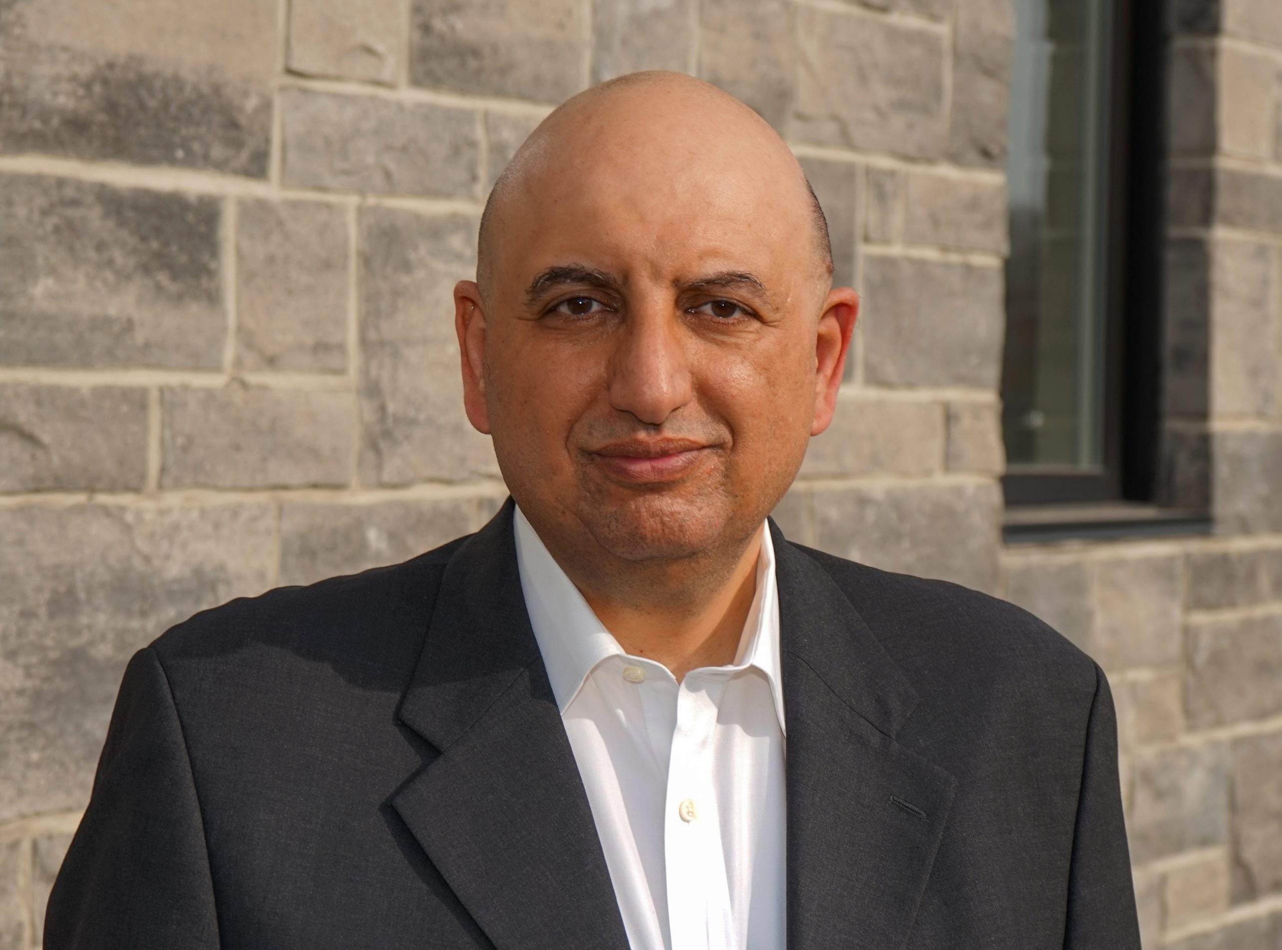 Headshot of Tarek Hussein looking at the camera wearing a suit 